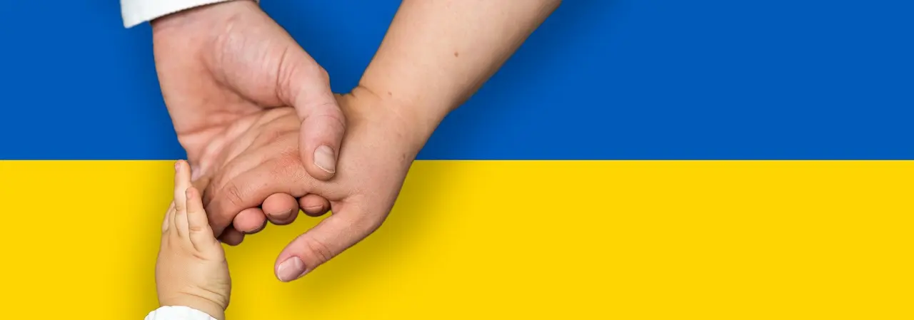 Ukrainische Flagge, davor drei ineinandergreifende Hände